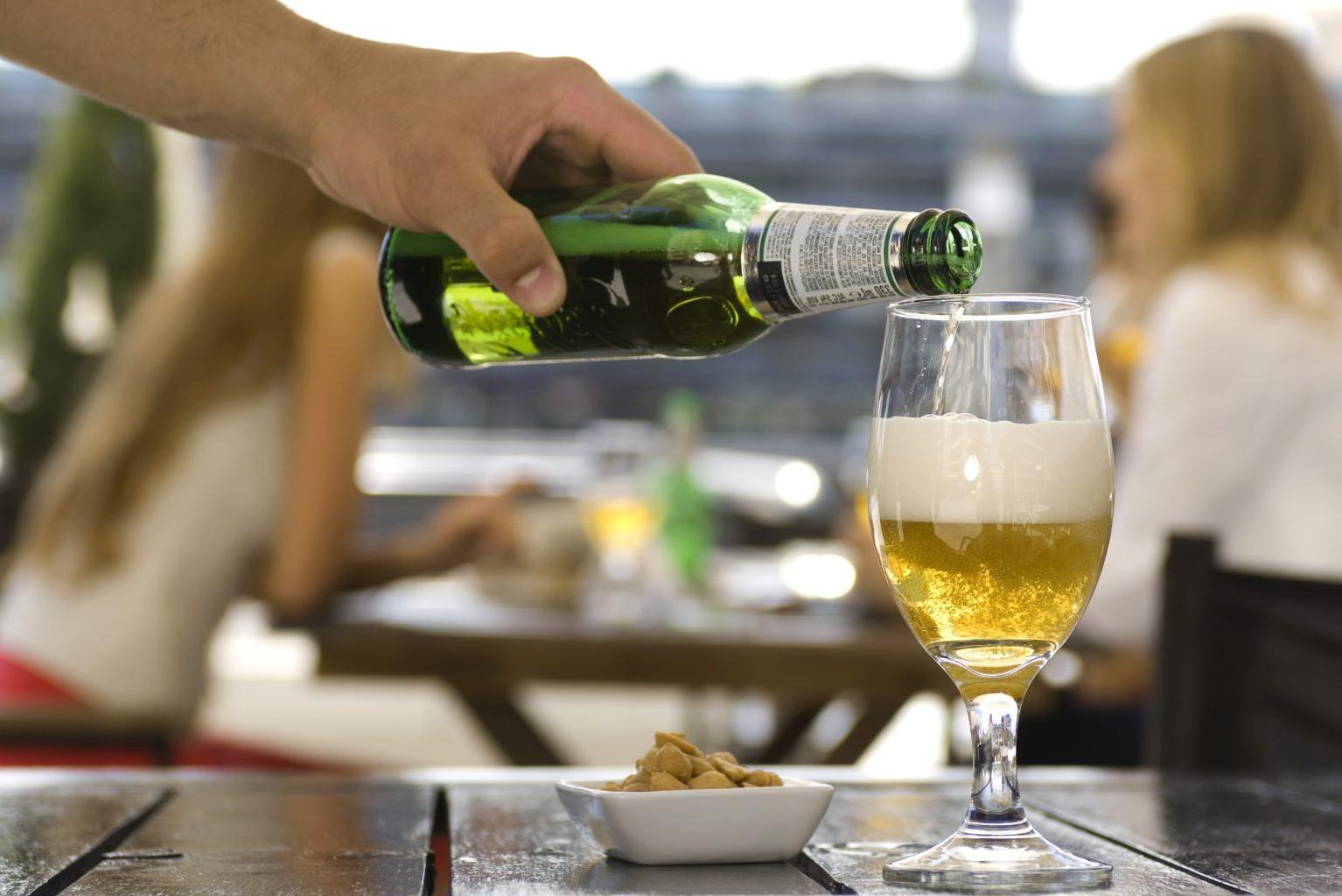 Pouring beer into glass at sidewalk cafe