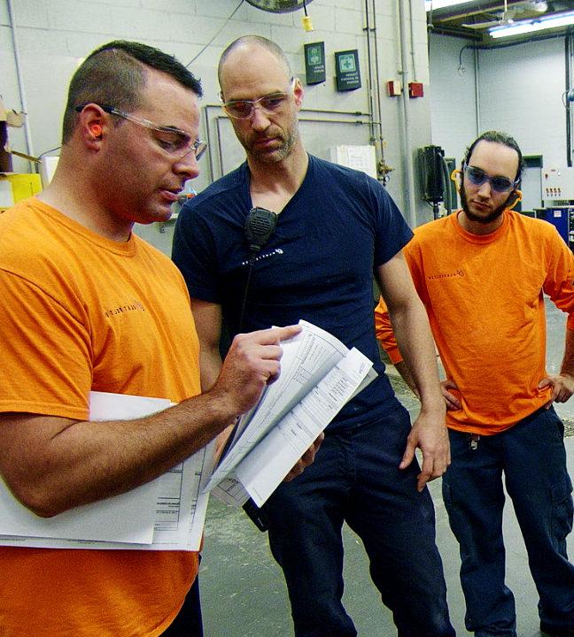 Three workers looking at documents